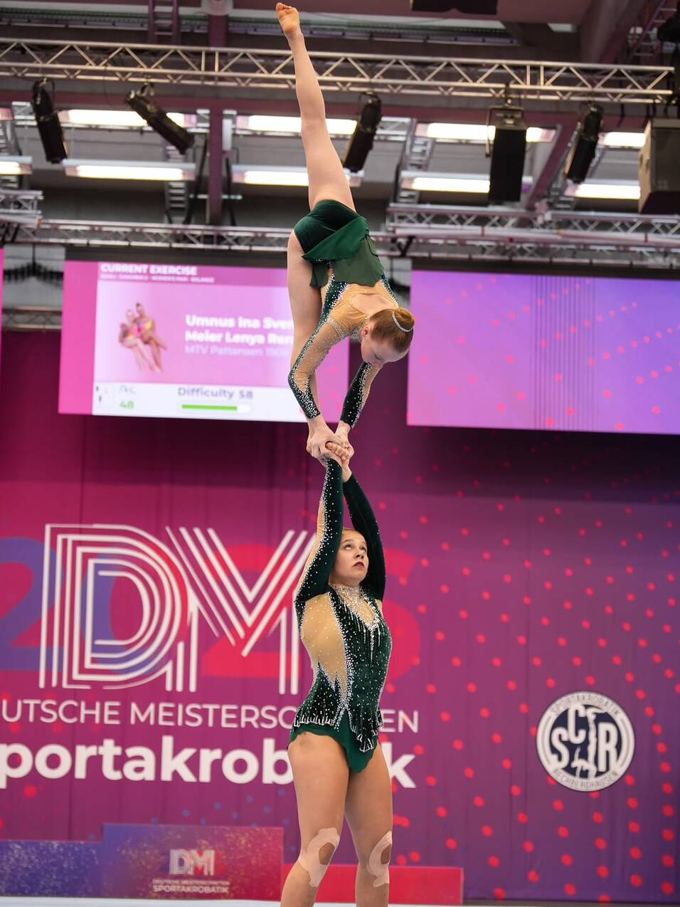 Zwei Akrobatinnen f&uuml;hren eine Hebefigur auf einer Gymnastikmatte w&auml;hrend der Deutschen Meisterschaften durch.