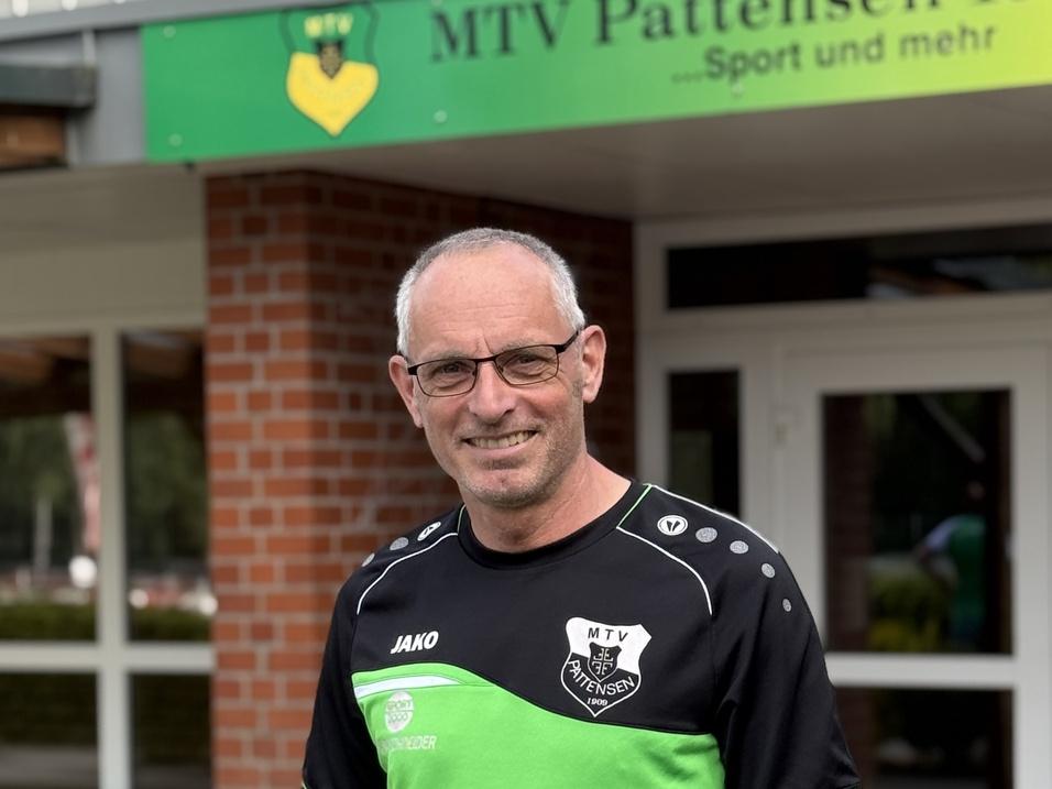 Mann mit Brille in Sportkleidung vor dem Eingang des MTV Pattensen Vereinsgebäudes.